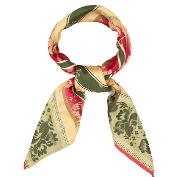 Bilde av dame med silkeskjerf knytet rundt halsen, over bunadskjorte og sølv.